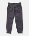 The Volcom Kids' Big Boys Frickin Slim Joggers in dark gray, made with recycled fibers, feature an elastic waist with drawstring, two side pockets, and elastic ankle cuffs; pants shown laid flat on a white background.