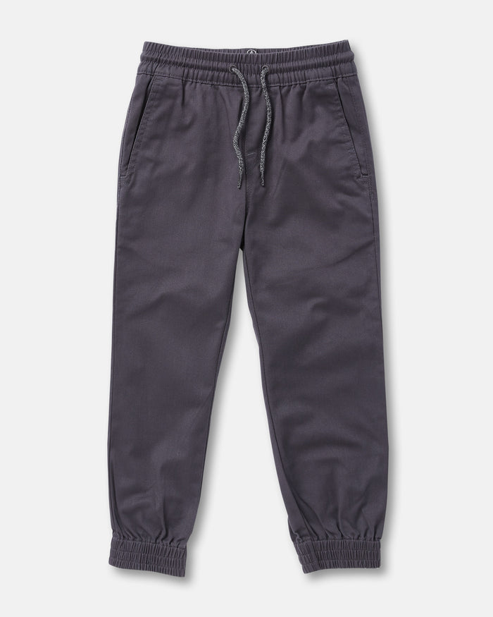 The Volcom Kids' Big Boys Frickin Slim Joggers in dark gray, made with recycled fibers, feature an elastic waist with drawstring, two side pockets, and elastic ankle cuffs; pants shown laid flat on a white background.