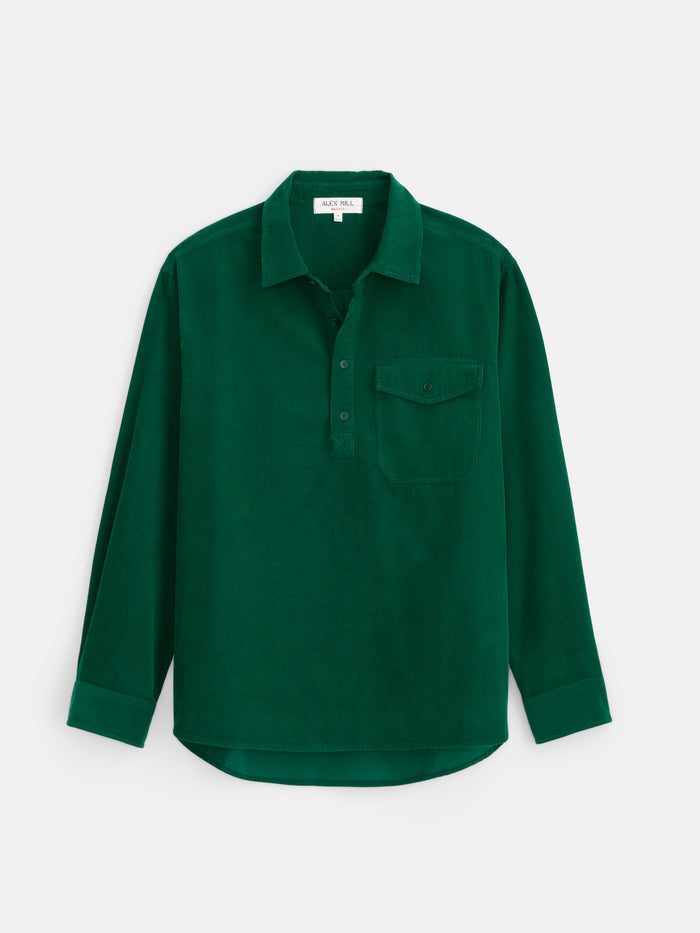 The Carter Popover In Fine Wale Corduroy is a long-sleeve, dark green shirt crafted from 100% cotton lightweight corduroy. It features a collar, front buttons, and a single chest pocket, and is shown laid flat on a white background.