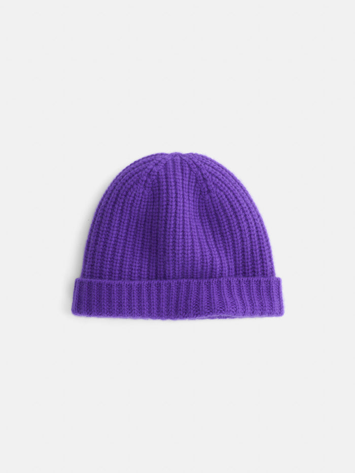 The Cashmere Beanie, crafted from soft cashmere for ultimate comfort, features a folded brim and comes in a rich purple knit, displayed on a plain white background.