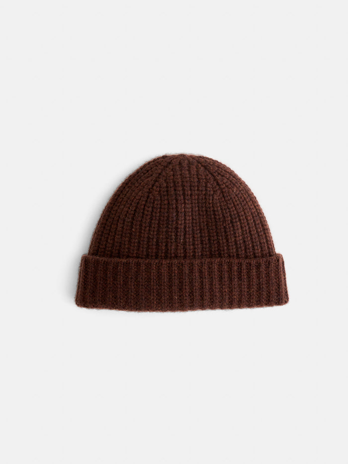 The Cashmere Beanie is a soft, brown knitted hat with a folded brim, shown on a plain white background.