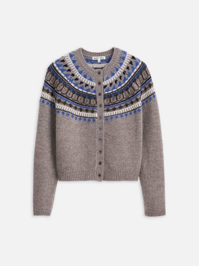 The Charlotte Fairisle Sweater in Wool is a gray women’s cropped knit with a round neckline, front buttons, blue, white, and brown fair isle yoke, and ribbed edges at the sleeves and hem for a classic touch.
