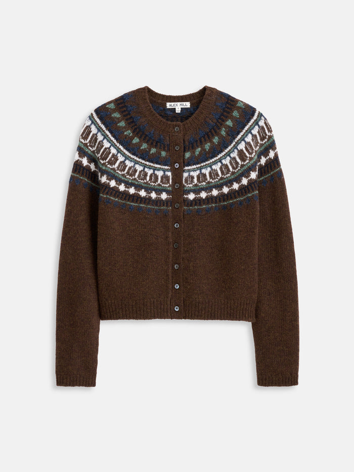 Introducing the Charolette Fairisle Sweater in Wool—a brown knitted cardigan with a classic round neck and front button closure, crafted from a cozy merino wool blend. This vintage-inspired piece features a blue, white, and green Fair Isle pattern across the yoke and shoulders, offering a timeless look that’s perfect for layering.