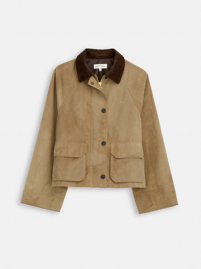 The Chiltern Cropped Jacket in waxed canvas features a tan finish, dark brown corduroy collar, black snap buttons, and two large front flap pockets. Displayed on a white background—an ideal piece for women's outerwear collections.