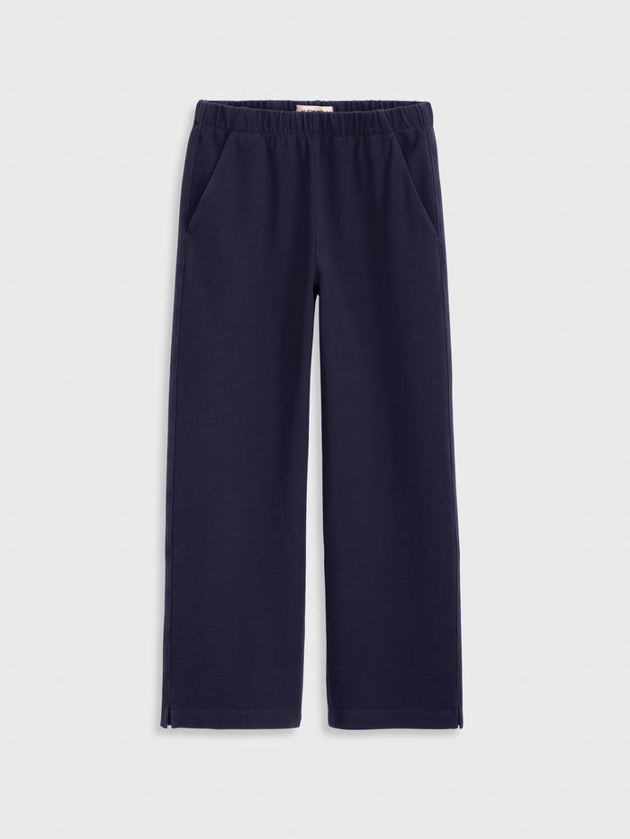Navy blue Coco Sport Pant in stretch cotton jersey, featuring a wide-leg silhouette, elastic waistband, and side pockets—women’s designer style displayed flat against a light gray background.