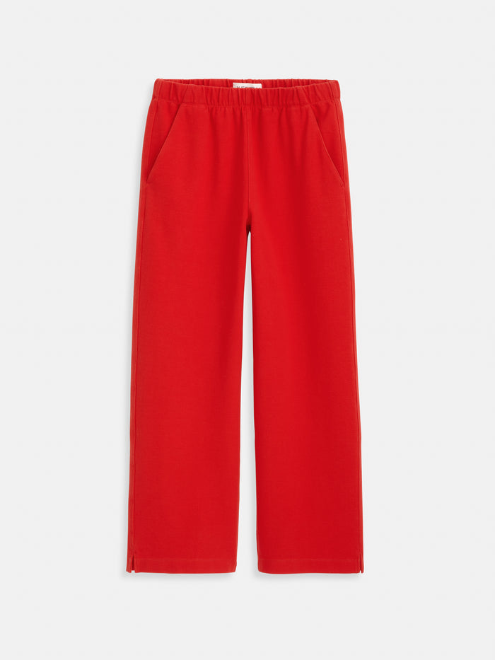 The Coco Sport Pant features bright red, wide-leg styling in stretchy cotton jersey with an elastic waistband, side pockets, and small hem slits—ideal to pair with your favorite Coco Cardigan. Shown against a plain white background.