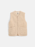 The Coldbreaker Standard Vest is a beige, sleeveless fleece vest made from 100% Irish wool with a front zipper and two large front pockets. Unisex sizing ensures it fits everyone, displayed here against a plain white background.