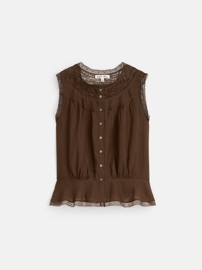 The Collette Top in Ramie is a sleeveless brown vintage-inspired top with lace trim on the collar, armholes, and hem, front buttons, and a ruffled peplum hem. Made from 100% ramie for a timeless look.