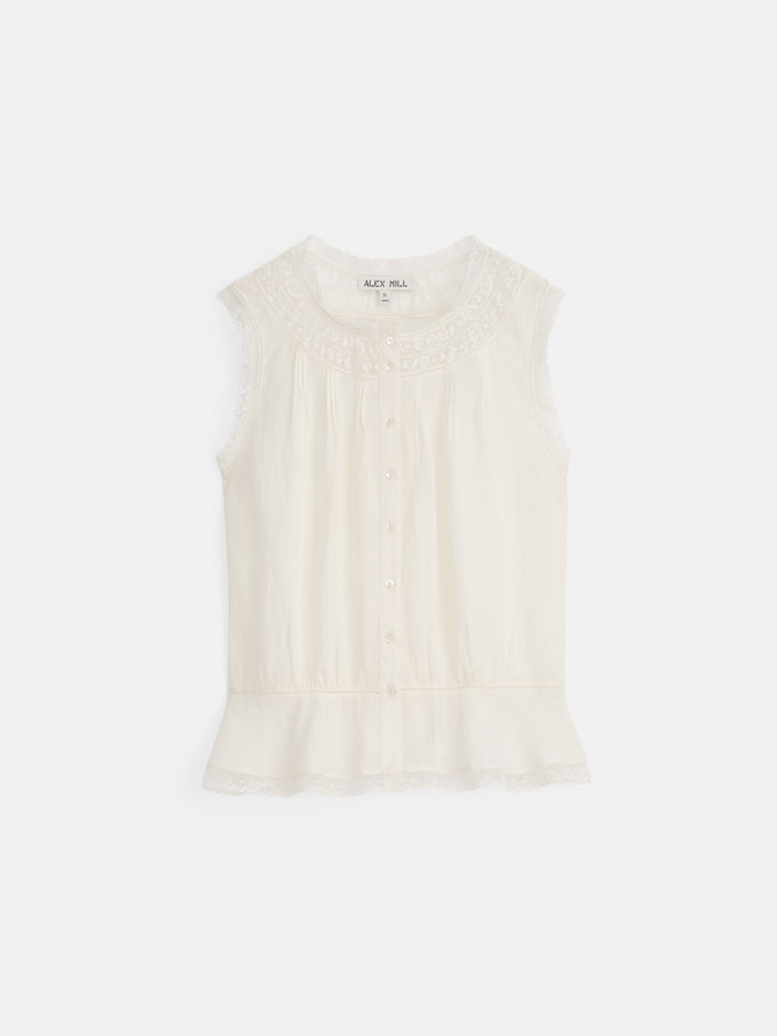 The Collette Top In Ramie is a sleeveless white blouse with lace-trimmed shoulders and hem, button-down front, peplum hem, and round neckline. The Alcy Hill brand label is visible inside the collar.