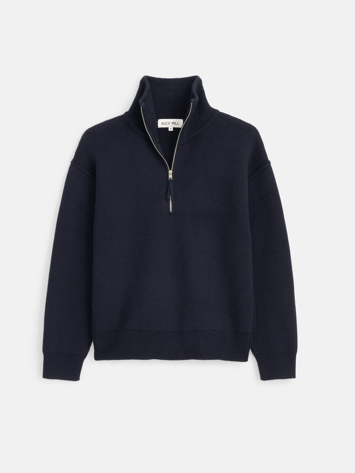 The Daphne Half-Zip Sweater in Cotton Cashmere is a navy blue long-sleeve sweater featuring a ribbed collar, cuffs, and hem. Crafted from a soft cotton-cashmere blend, it is shown laid flat on a white background.