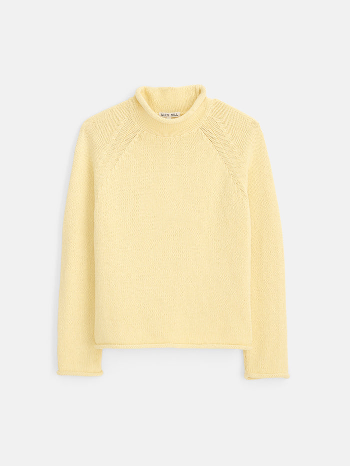 The Eastport Rollneck In Cotton is a light yellow, long-sleeve knit sweater made from 100% cotton, featuring a turtleneck collar and shown flat against a white background.