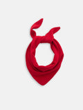 The Flynn Handkerchief Scarf in Wool, featuring a vibrant red color and pointed ends, is tied loosely in a knot and displayed against a plain white background.