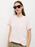 A woman in dark sunglasses, olive green pants with a brown braided belt, and the Garcon Striped Tee In Linen Cotton stands against a plain white background.