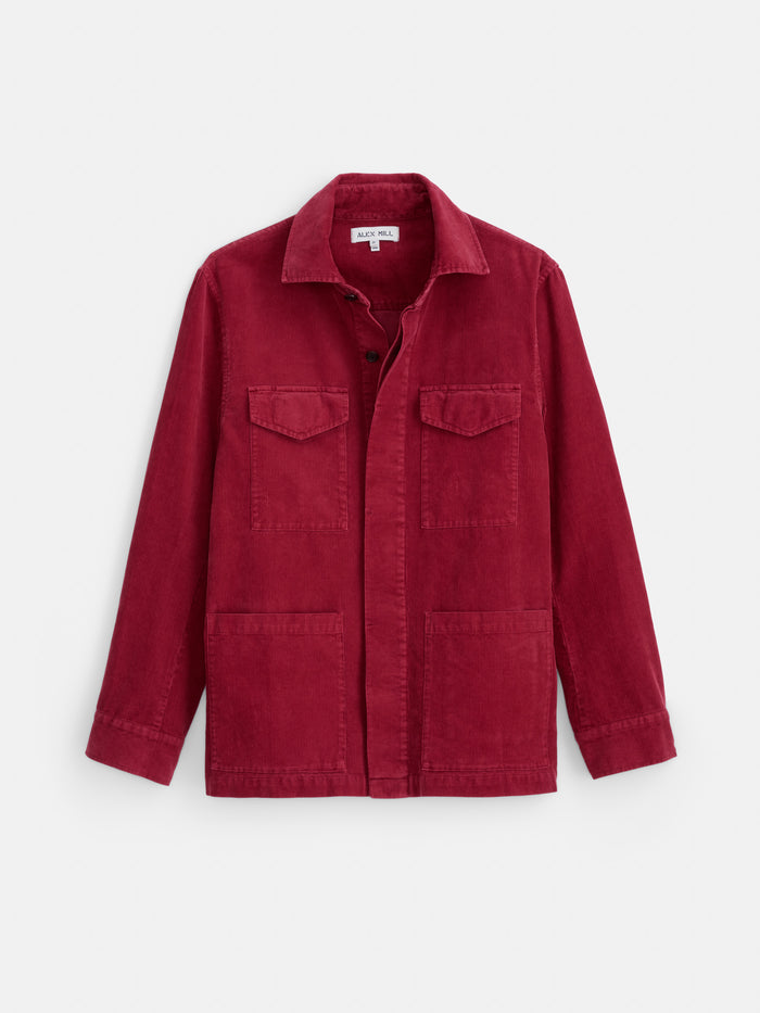 The Garment Dyed Chore Jacket in Corduroy is a long-sleeve, button-up red jacket made from fine-wale corduroy, featuring corozo buttons, two chest pockets, and two lower front pockets, shown laid flat on a white background.