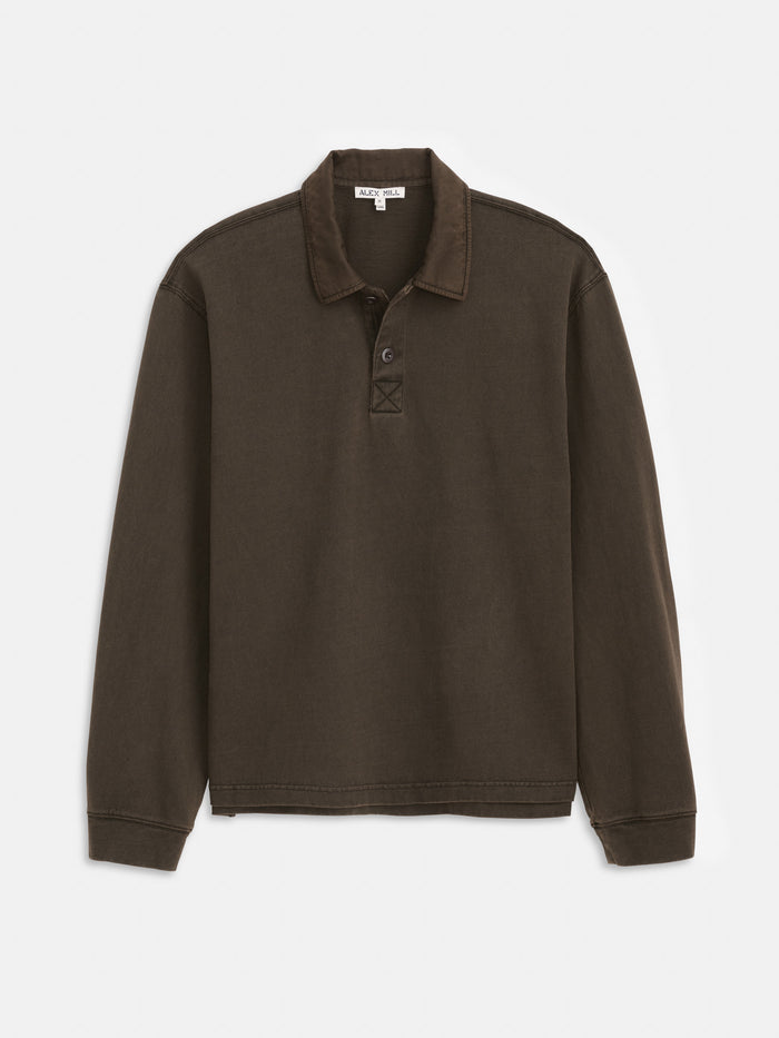 A long-sleeve, dark brown Garment Dyed Rugby Shirt in Cotton Jersey featuring a collar, two-button placket, and premium cotton-twill construction for a rich color. The boxy fit garment is shown laid flat on a white background.