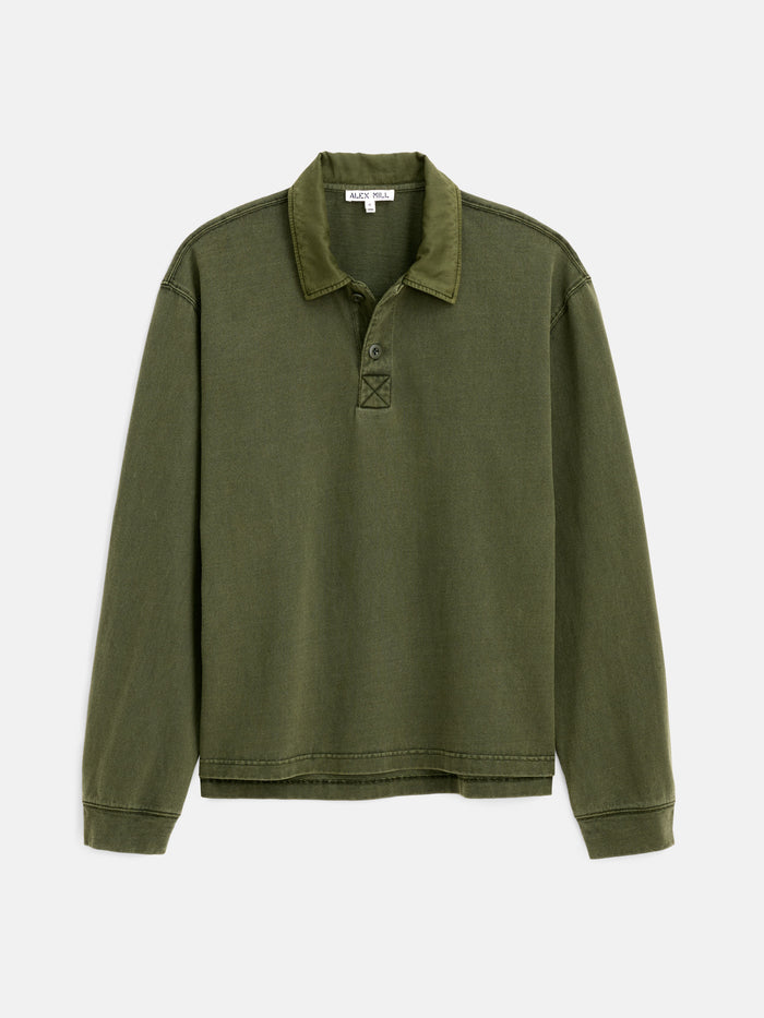 The Garment Dyed Rugby Shirt In Cotton Jersey is a men’s long-sleeve shirt in olive green, featuring a boxy, relaxed fit, visible stitching, and buttons at the neckline. Crafted from garment-dyed cotton jersey for enhanced softness and rich color, it is displayed laid flat on a white background.