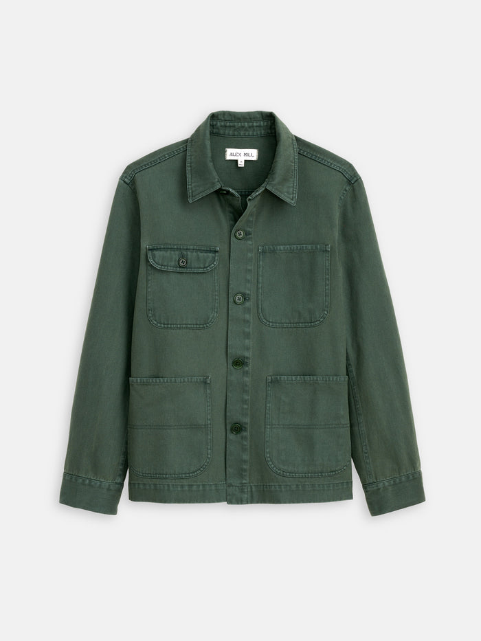 The Garment Dyed Work Jacket in Recycled Denim, shown in forest green against a white background, features a collar, button-up front, and four front pockets—three open and one buttoned.