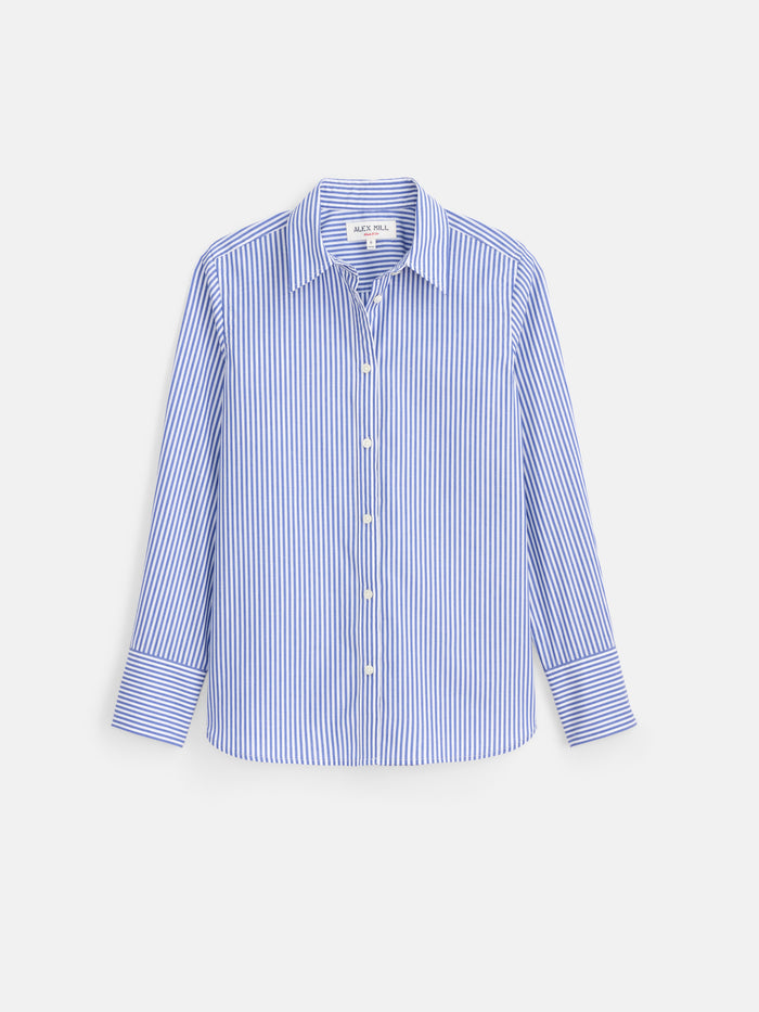 The Gracie Striped Shirt in Poplin is a classic button-up showcasing blue and white vertical stripes, long sleeves, and a crisp collar. Expertly crafted from 100% cotton poplin for a comfortable fit, this women’s shirt is perfectly tailored and displayed against a white background.