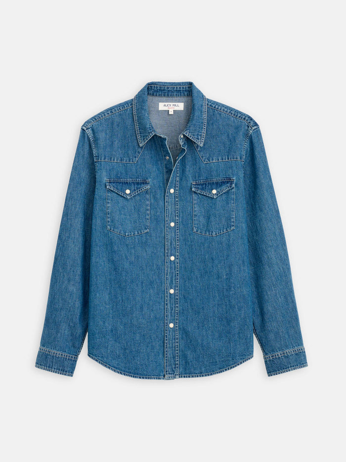 The Jackson Pocket Shirt In Denim is a long-sleeved, vintage-washed western shirt with a collar, snap buttons, and two flap chest pockets, shown against a white background.
