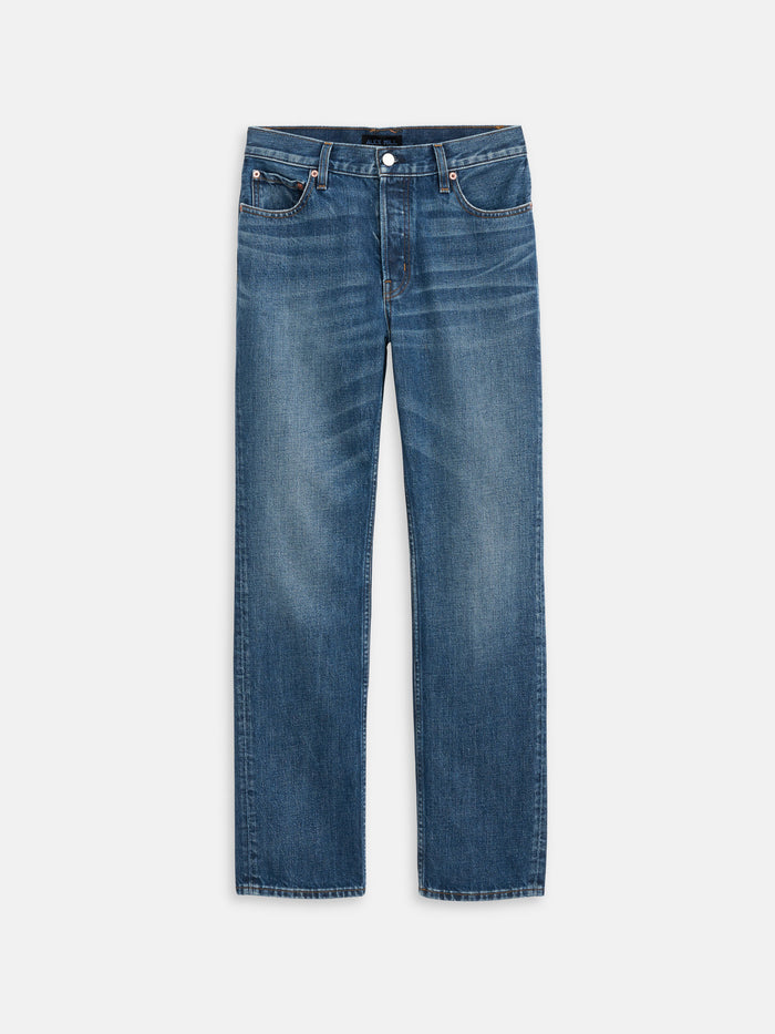 The Jane Mid Rise Straight Jean features a classic vintage look with a straight leg cut, five pockets, metal rivets, and denim accented by slight fading and whiskering on the thighs for a worn-in effect.