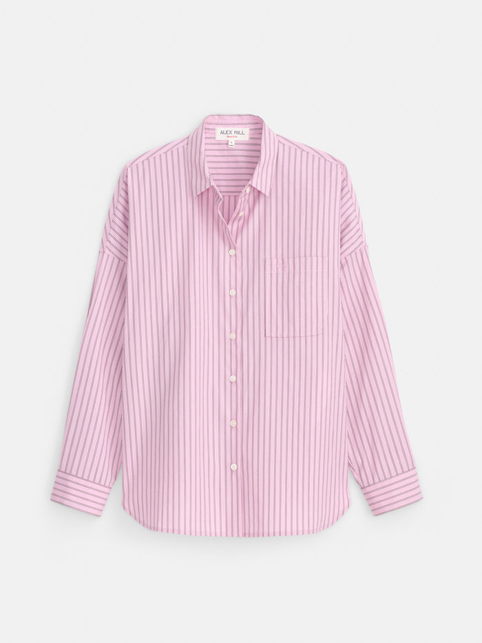 The Jo Shirt in Stripe Cotton Poplin, shown in pink with vertical stripes, features long sleeves, a button-up front, a single breast pocket, and French seams for a polished look. Crafted from 100% cotton and displayed flat on a white background.