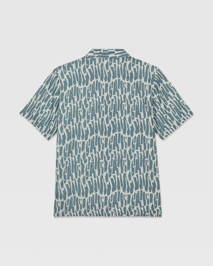 The Volcom Kids' Boldstone Short Sleeve Tee features a blue and white abstract brushstroke pattern, shown flat from the back.