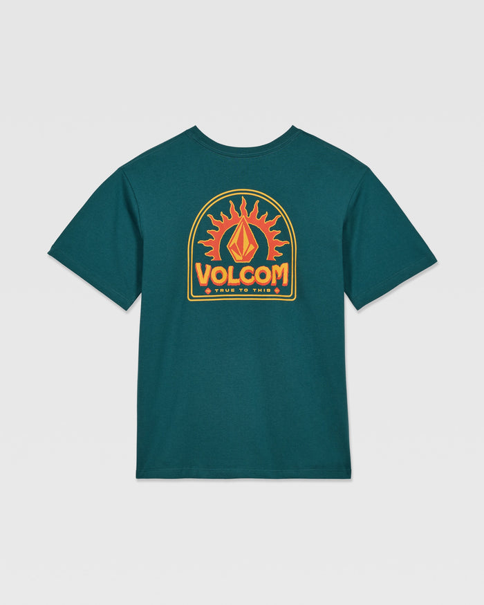 The Kids' Solstice Short Sleeve Tee by Volcom features a dark teal color and a bold back graphic with a stylized flame and “VOLCOM” in orange-yellow above “TRUE TO THIS”—perfect to pair with your favorite Volcom denim or low-rise jeans.