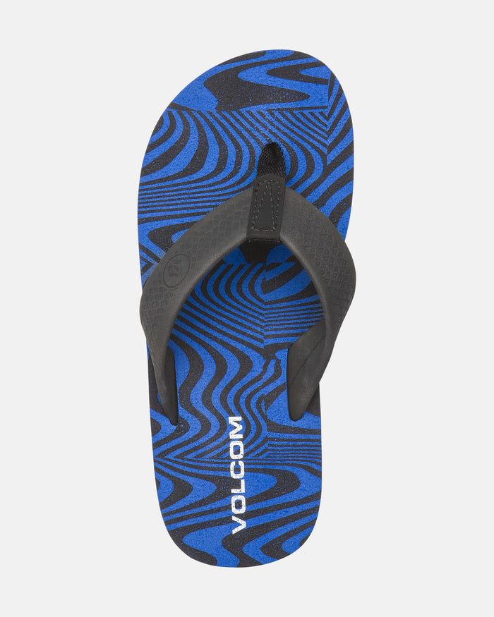 A single blue and black Kids' Daycation 2 Big Youth flip-flop by Volcom features a wavy, abstract pattern, black straps, white VOLCOM branding on the footbed, Recliner Comfort Foam, and arch support for all-day comfort.