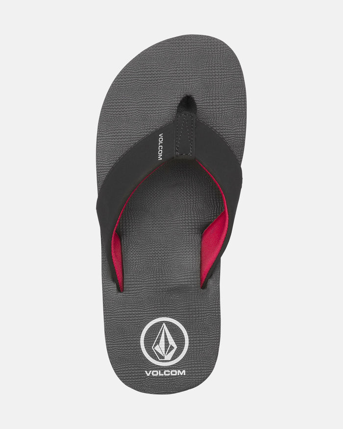 The Volcom Kids' Victor 2 Big Youth sandal is gray with black straps, a red inner lining, and features the Volcom logo and name near the heel. Water-friendly and designed for recliner-level comfort.