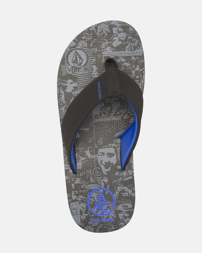 The Volcom Kids' Victor 2 Big Youth flip-flop features a gray and black patterned footbed with abstract graphics and logos, black straps lined in blue, a blue Volcom logo near the toe, and durable non-scuff outsoles.