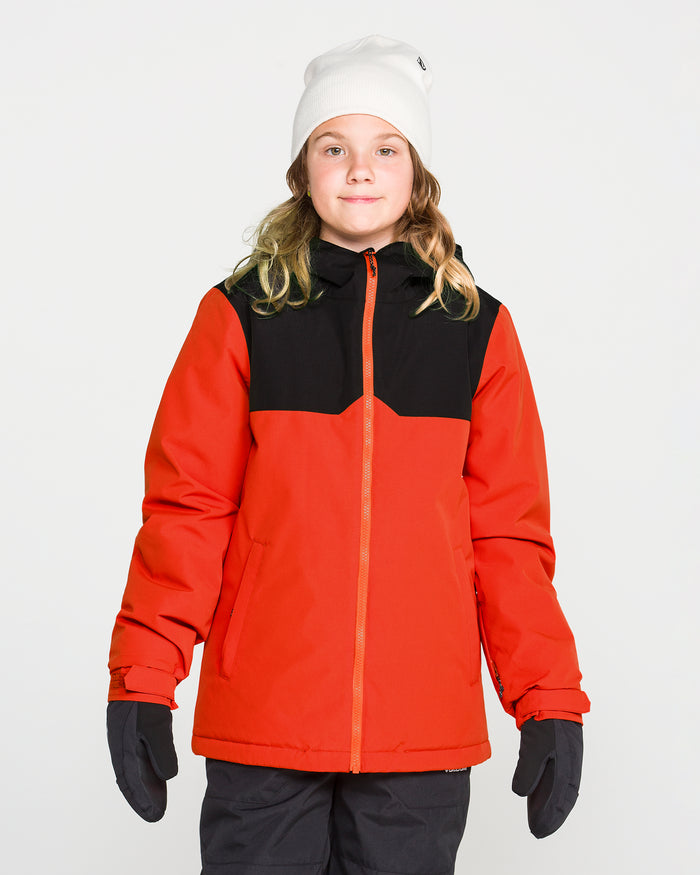 A child stands facing forward against a plain white background wearing the Volcom Kids’ Youth Stone.91 Insulated Jacket in red and black, featuring recycled insulation, along with a white beanie and gloves.