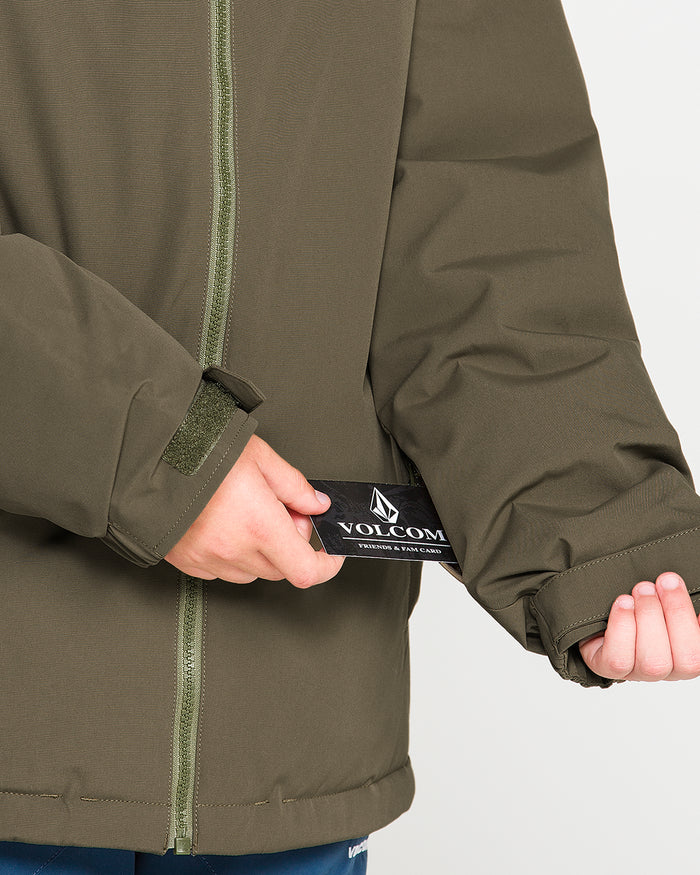 A person wearing the Volcom Kids’ Youth Stone.91 Insulated Jacket in olive green adjusts the Velcro cuff with one hand while holding a black Volcom tag with the other. The jacket, made with recycled insulation for added warmth, is displayed from torso to hands against a neutral background.