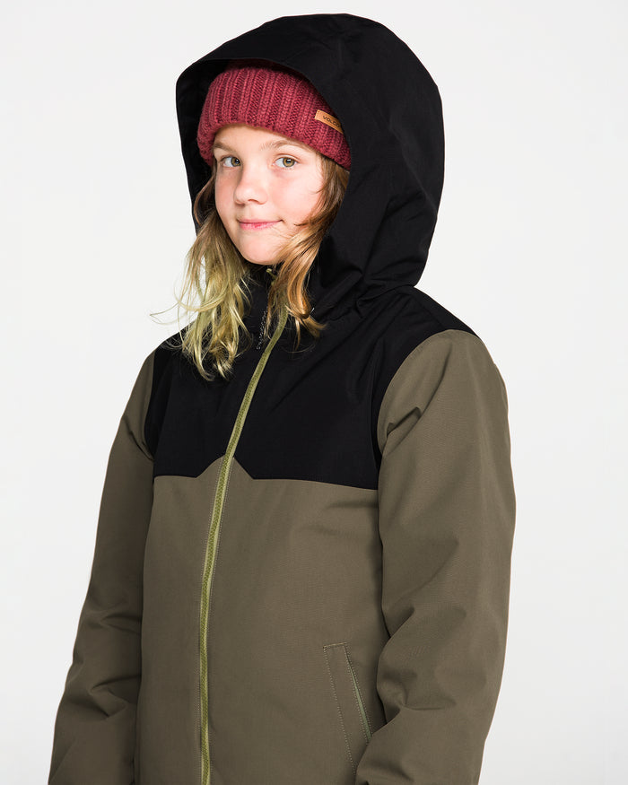 A child wearing a maroon knit beanie and the Volcom Kids’ Youth Stone.91 Insulated Jacket in olive green with black shoulders and recycled insulation looks at the camera against a plain white background.