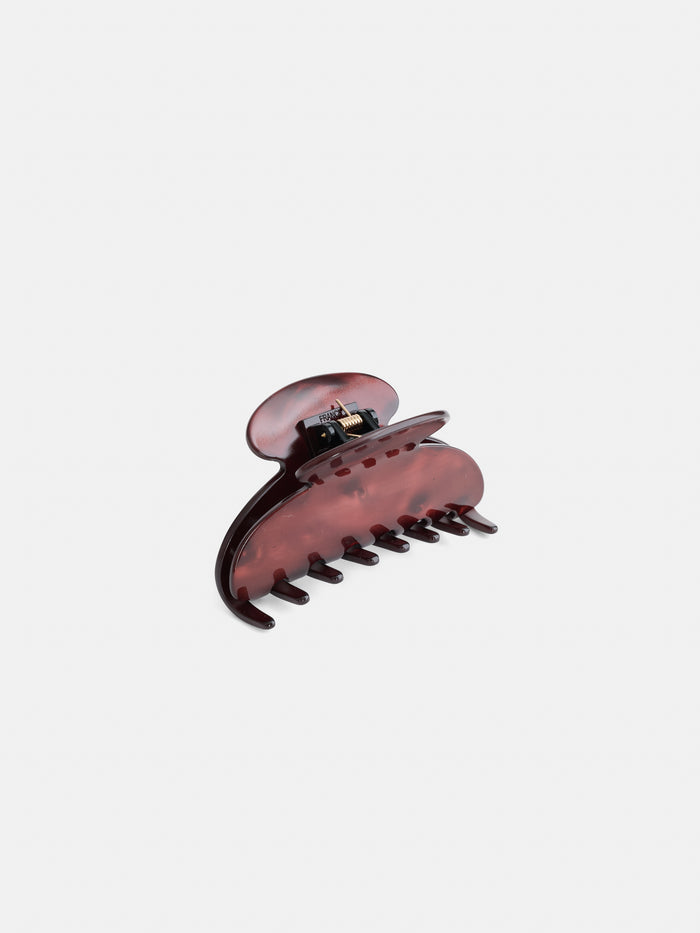 The Large Round Claw is a maroon acetate hair clip with a spring hinge, shown standing upright against a white background. Handcrafted in France, this elegant accessory combines exceptional quality with timeless style.