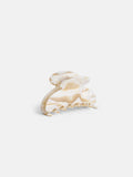 The Large Round Claw is a beige and cream marbled acetate hair clip with a curved, rounded top and interlocking teeth, handcrafted in France, shown against a plain white background.