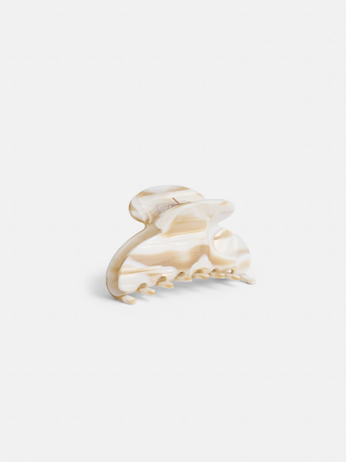 The Large Round Claw is a beige and cream marbled acetate hair clip with a curved, rounded top and interlocking teeth, handcrafted in France, shown against a plain white background.