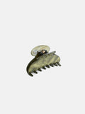 The Large Round Claw is a green marbled hair claw clip, handcrafted in France from premium acetate, featuring a curved design and interlocking teeth, displayed against a plain white background.