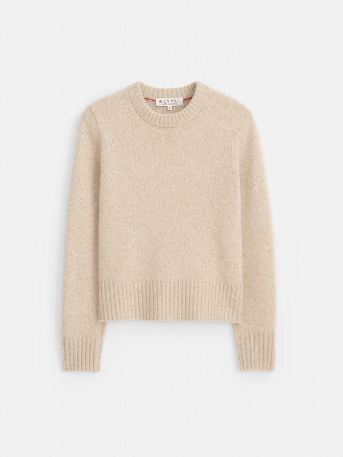 The Marais Sweater in Cashmere is shown flat on a white background, featuring a beige hue, long sleeves, and finished with ribbed detailing at the crew neckline, cuffs, and hem. Expertly crafted from 100% cashmere, it offers exceptional softness and an elevated sense of luxury.