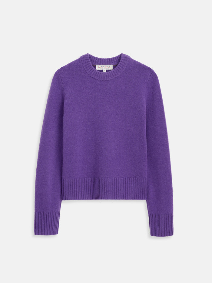 The Marais Crewneck Sweater in Cashmere, shown in purple and laid flat on a white background, features long sleeves, a crew neck, and ribbed cuffs, hem, and neckline for a luxurious finish.