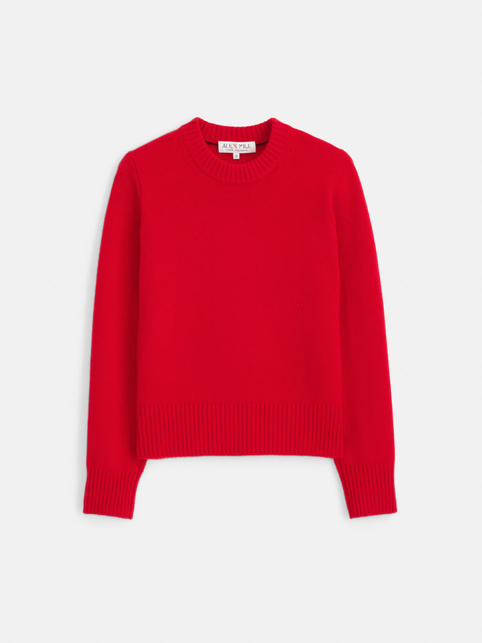 The Marais Sweater in Washed Cashmere is displayed flat on a white background, showcasing its vibrant red color and long-sleeve, crew neck design. Made from 100% cashmere for exceptional softness, it features ribbed cuffs, collar, and hem, with a visible tag at the neckline.