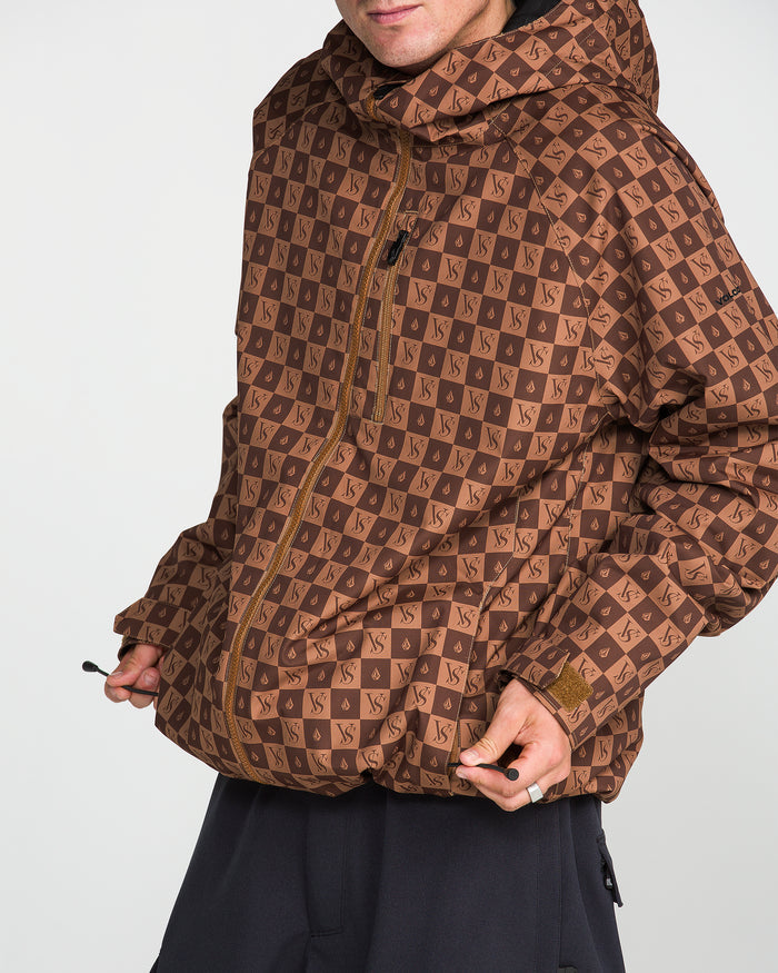 A person wearing the Volcom Men’s 2836 Insulated Jacket in brown, featuring a repeating VS pattern and zip-up hooded design, pulls on the drawstring at the hem. The men’s jacket offers V-Science 2-Layer construction for enhanced protection, with the wearer’s face partially out of frame against a plain white background.