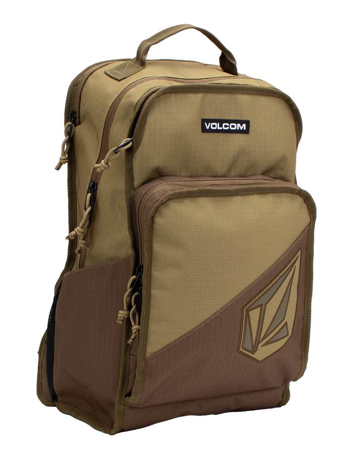 The Volcom Men's Boundary Backpack in brown and tan features multiple zippered compartments, a top handle, and a spacious front pocket with the Volcom logo. Designed for durability, this backpack includes a convenient laptop compartment, making it ideal for everyday use or travel.