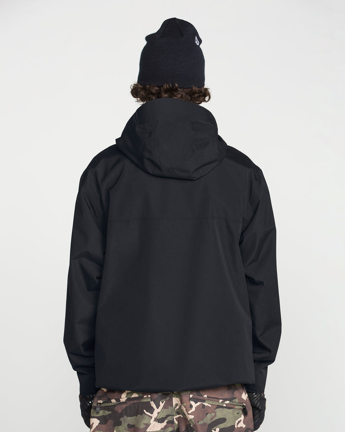 A person stands facing away from the camera against a plain white background, wearing the Volcom Men’s Buckthreeeighty Insulated Jacket in black—crafted from recycled fabric and featuring a hood—paired with a black knit beanie and camouflage pants.