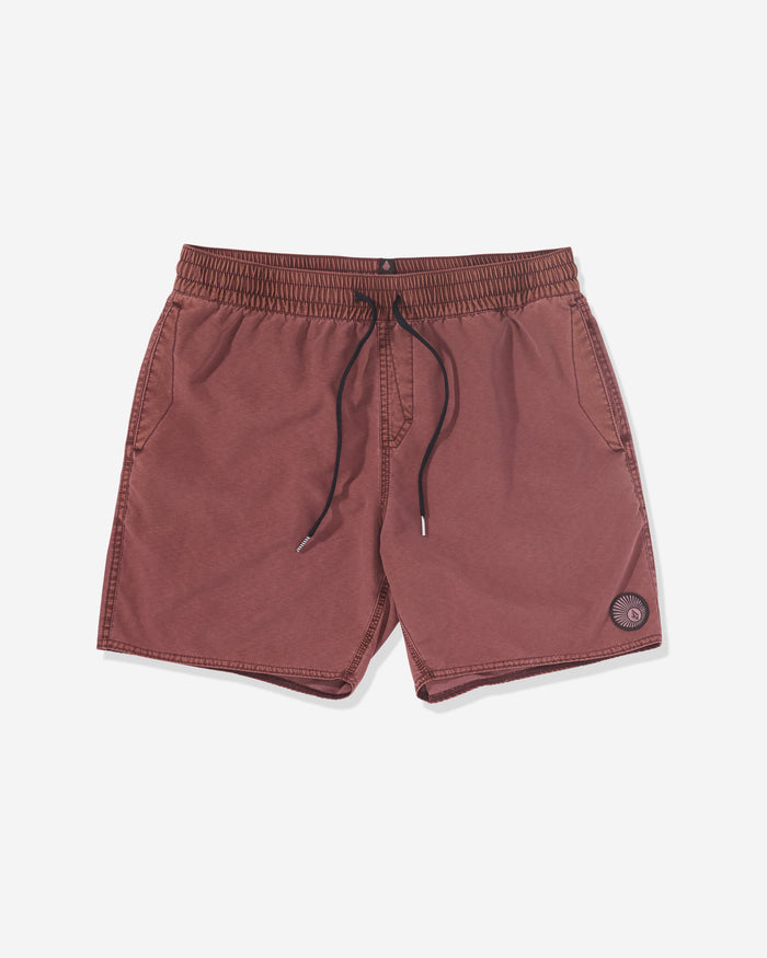 The Volcom Men's Center Elastic Waist Trunks are maroon, mid-length, with side pockets, an elastic waistband, and a small circular patch on the lower left leg. Crafted from a comfy polyester blend and shown on a white background.