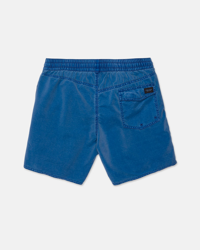 Men’s Center Elastic Waist Trunks by Volcom in blue, featuring an elastic waistband, a single back pocket on the right side with a small black rectangular label above it. The slightly textured 17-inch boardshorts are displayed flat on a white background.