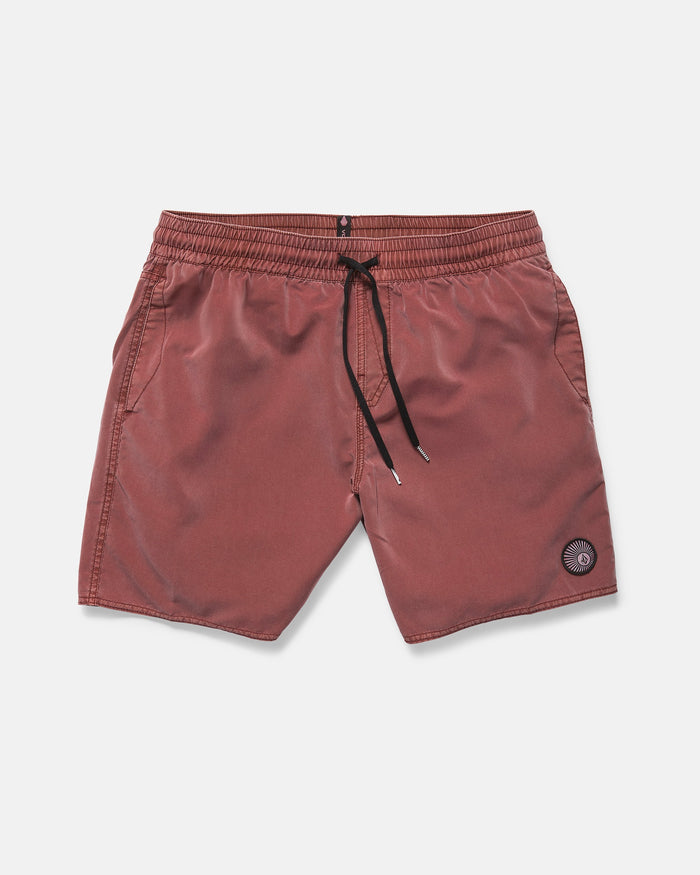 Volcom Men's Center Elastic Waist 17" Trunk swim shorts in red-brown, featuring mechanical stretch, side pockets, and a circular patch logo on the left leg, shown against a plain white background.