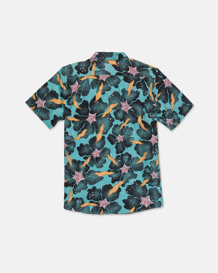 Men's Concrete Jungle Short Sleeve Shirt by Volcom features a vibrant underwater pattern with fish, seaweed, and starfish on a teal background. Made from breathable cotton-viscose for comfort, this classic fit shirt is displayed flat with the back facing up.