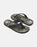 The Volcom Men's Daycation 2 Hawaii Sandals feature black straps and patterned soles with abstract green, beige, and black designs, plus a white circular logo near the heel on each sandal.