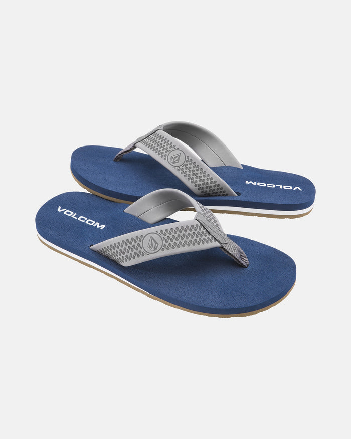 Volcom Men's Daycation 2 flip-flops with blue soles, grey and white textured straps, a molded footbed for comfort, and Volcom logos on the footbeds and straps, displayed on a white background.