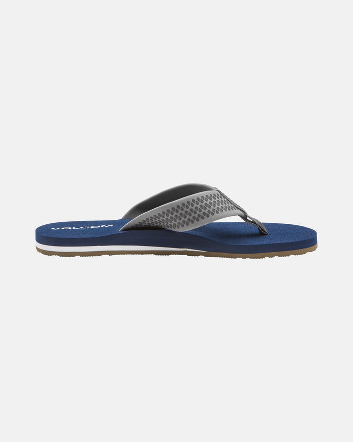 The Volcom Men's Daycation 2 sandal is shown in side profile, featuring a blue EVA sole, textured gray strap, black accents, and a molded footbed on a plain white background.